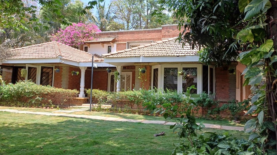 The tiled-roof Namma Ashram building seen across its garden in Whitefield, Bengaluru