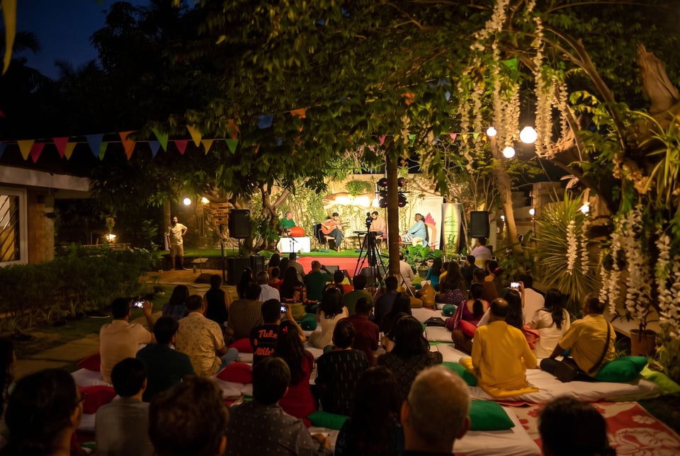 An evening gathering under lit trees on the Namma Ashram lawn