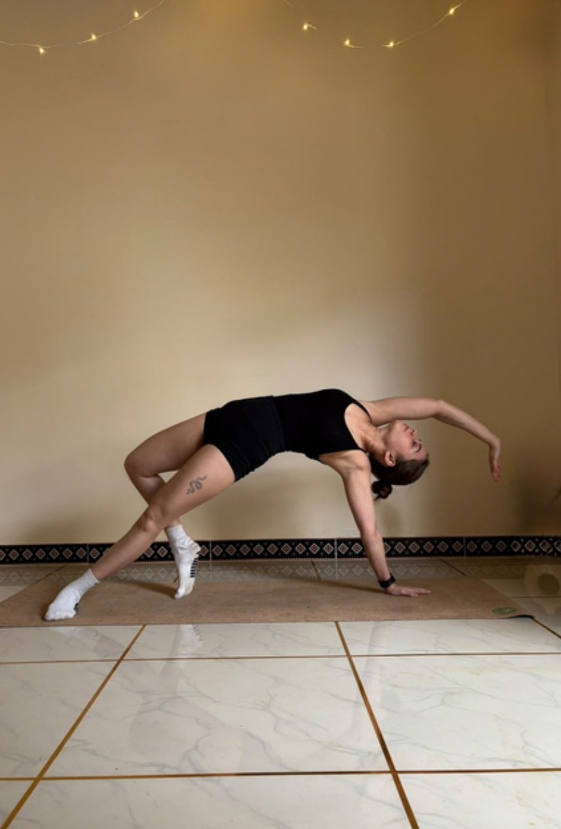A practitioner in a flowing backbend on the studio floor